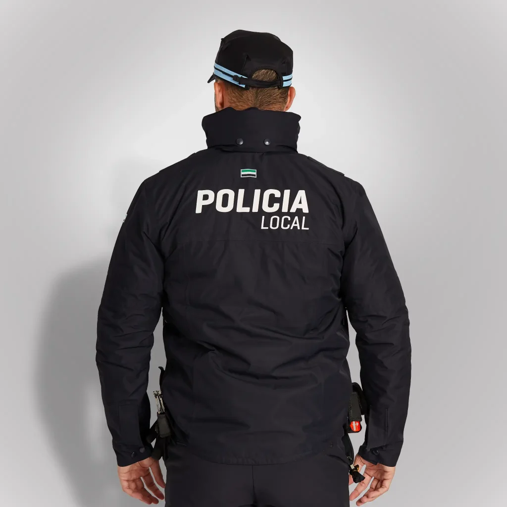 Agente de espaldas vistiendo cazadora policial técnica e impermeable azul noche de Castilla la Mancha | Serie Origen | Satara